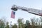 American flag hanging from fire truck ladder