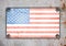 American flag on metal plate screwed screws on wall