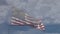 American flag slow motion waving in wind with ghosted time-lapse clouds