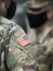 American flag on soldier arm and US soldiers wearing protective face masks. Quarantine in army. Military forces of the United