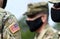 American flag on soldier arm and US soldiers wearing protective face masks. Quarantine in army. Military forces of the United