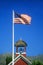 American flag waving above one room schoolhouse,