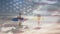 American flag waving against african american couple with surf boards running on the beach