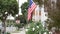 American flag waving, suburban house facade residential district, California USA