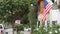 American flag waving, suburban house facade residential district, California USA