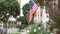 American flag waving, suburban house facade residential district, California USA