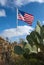 American flag waving in the wind against a background of wildlife, cacti and agave in Texas