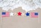 American flags with starfishes on the sandy beach