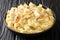 American food stewed chicken a la King in a creamy sauce with mushrooms served with pasta close-up in a plate. horizontal