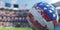 American football ball close-up, blurry stadium and stands in the background