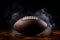 American football ball enveloped in smoke, dramatic close up on black