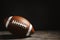 American football ball on table against dark background