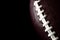 American football  and gameday poster concept with close up on the texture of a ball with dramatic moody light with high contrast