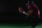 American football player sitting on toes holding a ball with both his hands