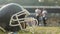 American football players having break on field, drinking water, communicating