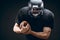 American football sportsman player in action isolated over black studio wall