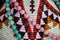 American Indian decor background - pink and turquoise beads draped on a colorful textile woven design closeup and shallow focus