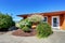 American orange house exterior. Flower bed and bushes in front