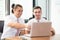 American people business two young caucasian modern man sitting in a meeting room using and looking laptop together.