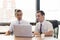 American people business two young caucasian modern man sitting in a meeting room using and looking laptop together.