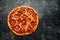 American pepperoni cheese pizza on rustic black background