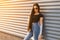 American pretty beautiful young woman hipster in sunglasses with long hair in a stylish t-shirt in a summer jacket in blue jeans