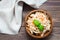 American ready-to-eat cole slaw salad of cabbage, celery, carrots and apple with basil leaves in a wooden plate and forks