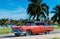 American red Ford classic car with black roof parked under blue sky near the beach in Havana Cuba - Serie Cuba Reportage