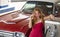 American Retro Car. Gas station, woman refuel the car. Red retro automobile.