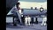 American sailors in uniform climb the ladder of a vintage passenger plane