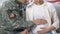 American serviceman stroking pregnant wife belly, family planning, young couple