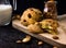 American shortbread cookies with chocolate drops and a jug of milk and almonds. Dark grunge background. Mystical light