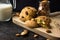 American shortbread cookies with chocolate drops and a jug of milk and almonds. Dark grunge background. Mystical light