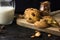 American shortbread cookies with chocolate drops and a jug of milk and almonds. Dark grunge background. Mystical light