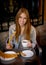 American student tourist girl sitting having spanish typical hot chocolate with churros smiling happy