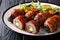 American Texas Armadillo eggs with jalapeno and cheese wrapped in bacon served with fresh salad close-up on the table. horizontal