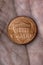 American US coin 1 cent penny lies on a dirty palm close up. An impressive, dramatic vertical shot with an aged effect. Low-wage