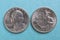 American US coins lie on a light blue background. Denomination: 25 cents, quarter, drummer, 1976. Both sides: obverse and reverse