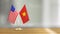 American and Vietnamese flag pair on a desk over defocused background
