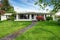 American white rambler with green grass and flower bed.