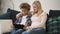 American woman and multi ethnic boy is sitting on sofa together and watching online
