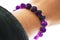 Amethyst bracelet on the wrist. Spiritual and healing crystal gemstone.  Purple or violet crystal stone.