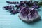 Amethyst and healing herbs on blue wooden table, closeup