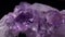 Amethyst mineral crystals macro video with slow rotation over a black background