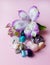 Amethyst, rhinestone, agate, rose quartz, aquamarine and alstroemeria flowers on a pink background