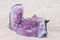 Amethyst rock on sand background