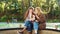 Amiable stylish girls browsing social media in beautiful park