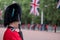 Amid tight security, Royal Guards in red and black uniform and bearskins line The Mall in London for Trooping the Colour Parade