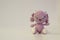 Amigurumi hare of pink color, sitting on a white background. Needlework concept