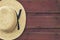 Amish man\'s straw hat hangs on a red barn door